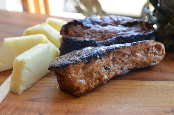 Vegan ribs on a board with slices of pineapple