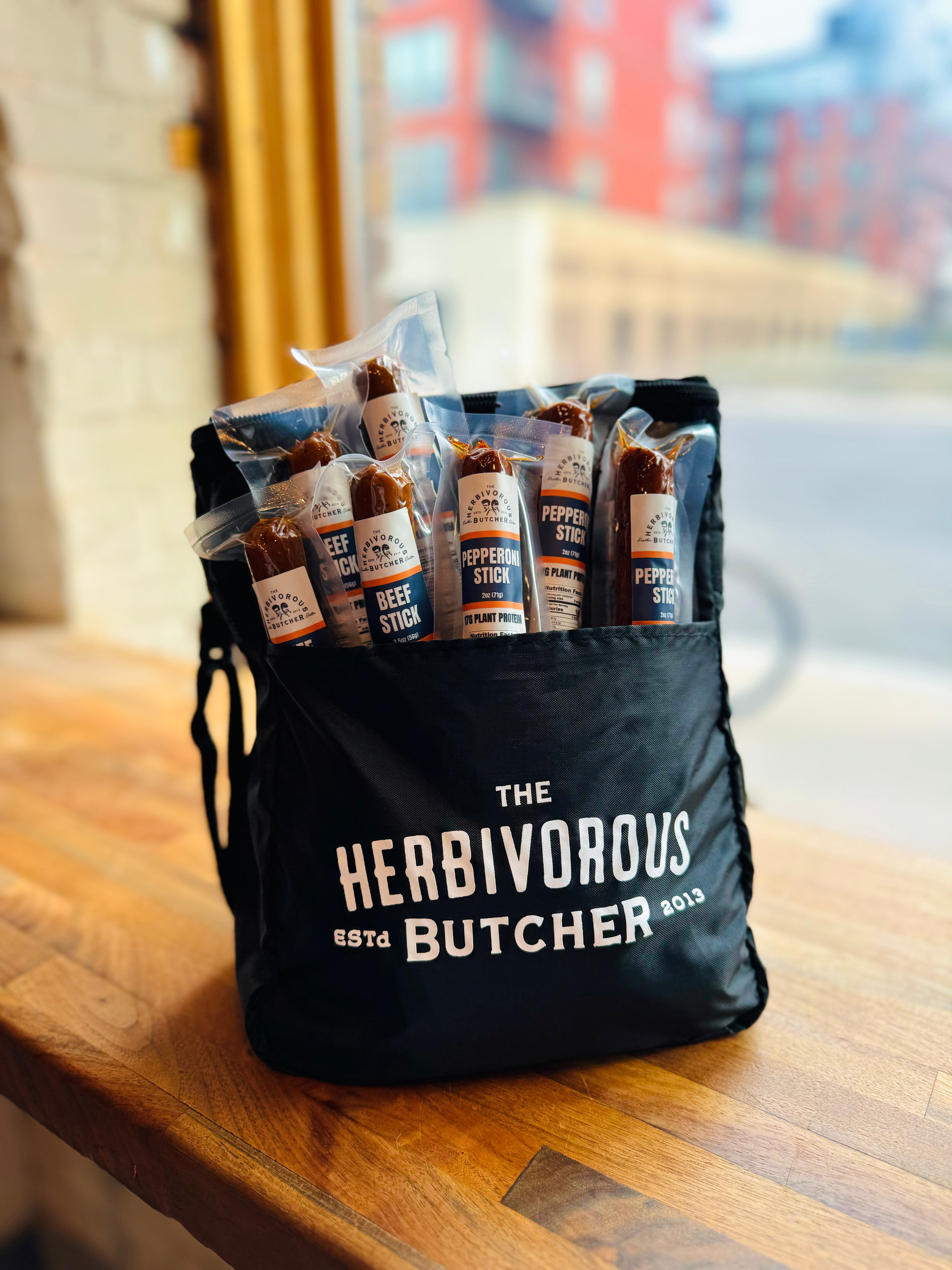 A Herbivorous Butcher cooler bag filled with vegan pepperoni and beef sticks