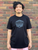 person wearing a black t shirt with The Herbivorous Butcher logo on it