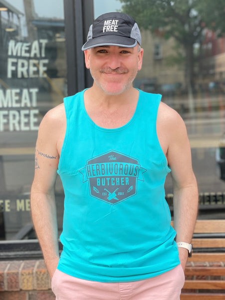 person wearing a meat-free hat and a turquoise tank top with The Herbivorous Butcher logo on it