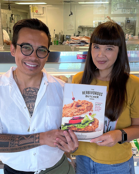 a brother and sister holding The Herbivorous Butcher Cookbook