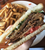 cross section of a vegan BLT with a side of fries in the background