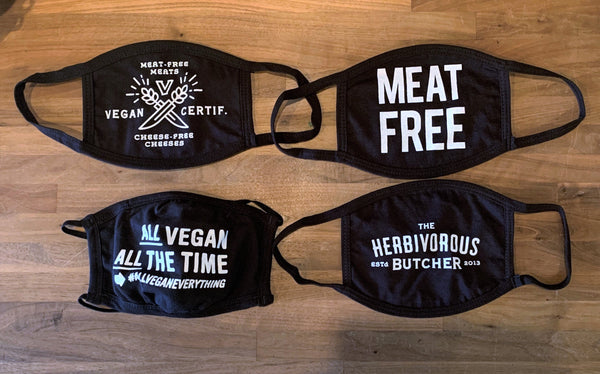 four black face masks with vegan messaging