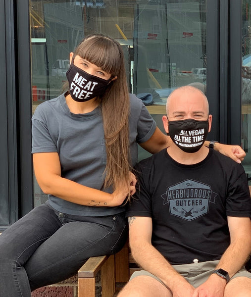 Two people wearing black face masks with vegan messaging