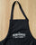 top half of a black apron with The Herbivorous Butcher logo in white