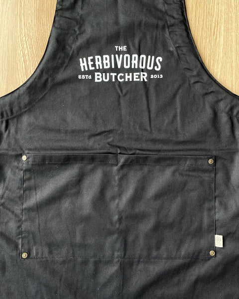 torso area of a black apron with The Herbivorous Butcher logo in white