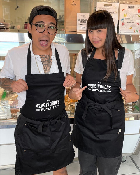 a brother and sister wearing black aprons with The Herbivorous Butcher logo