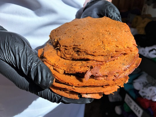 hands holding slices of vegan deli meat