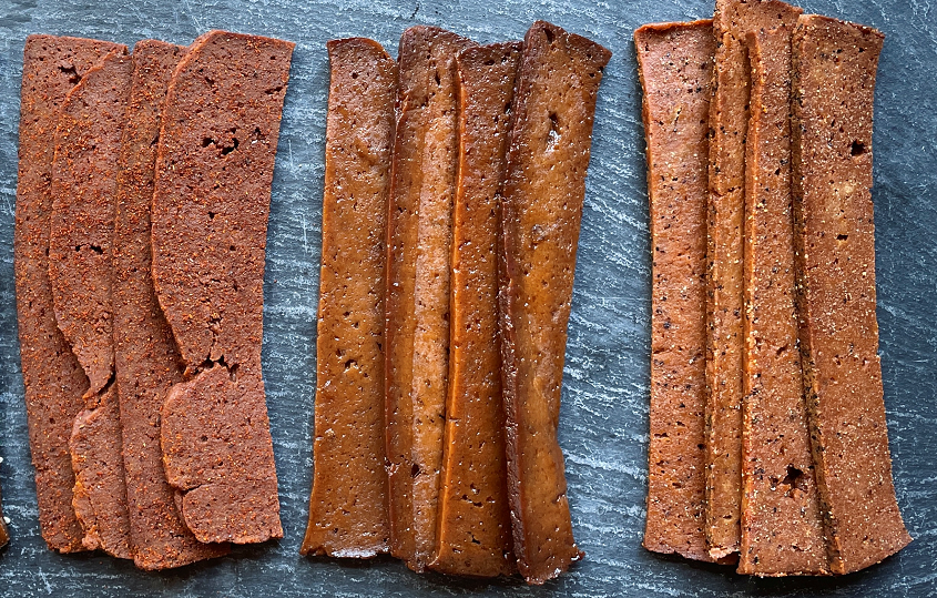 three piles of vegan plant based jerky with different flavors